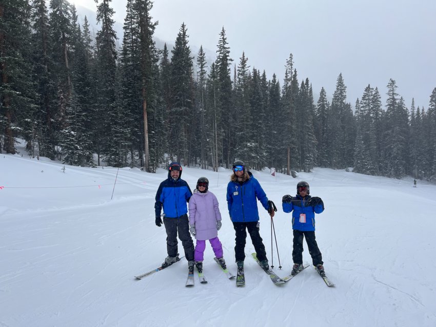 Two students pose with their ski instructor and teacher, Peter Zola.